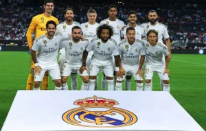 Đội hình câu lạc bộ bóng đá Real Madrid chụp cùng logo truyền thống