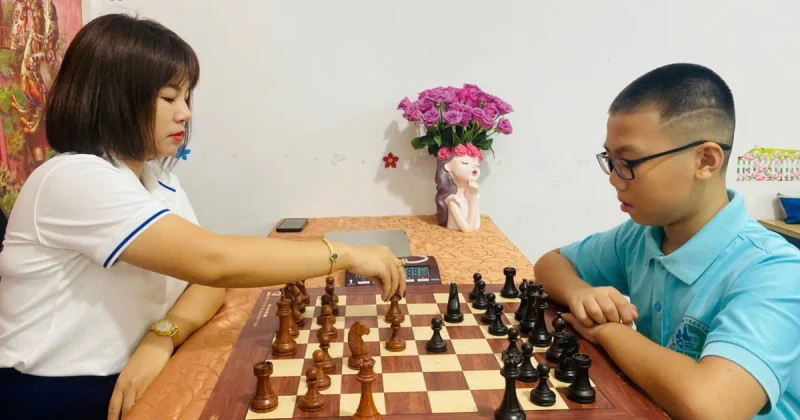 Hai người đang tập trung chơi cờ vua trong không gian gia đình
