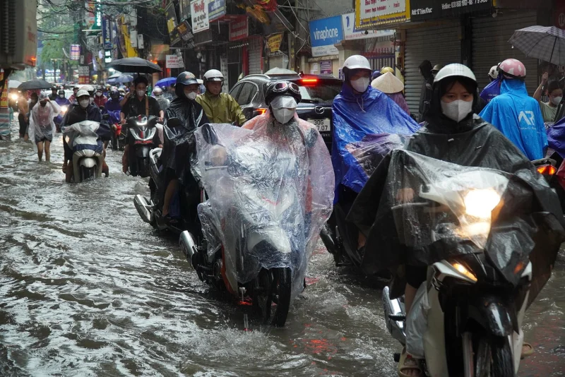 Người dân di chuyển khó khăn trên tuyến phố Hà Nội ngập úng vì mưa lớn
