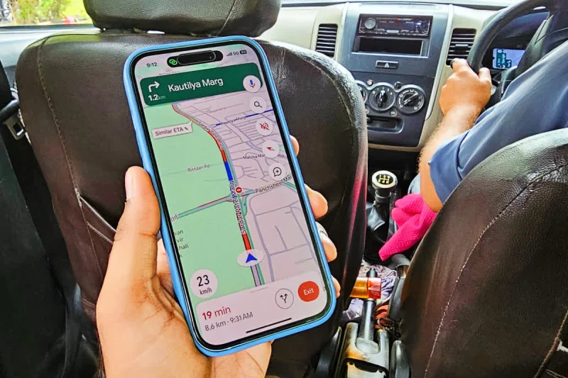 Người dùng cầm điện thoại xem bản đồ Google Maps cảnh báo tắc đường khi đi ô tô