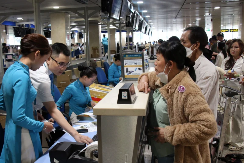 Nhân viên Vietnam Airlines hỗ trợ hành khách làm thủ tục ký gửi hành lý tại sân bay