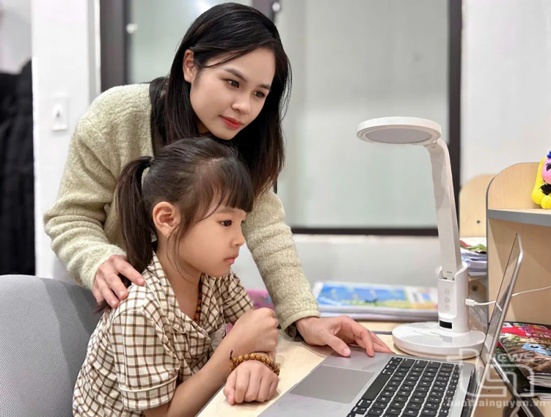 Mẹ hướng dẫn con gái sử dụng máy tính an toàn tại nhà