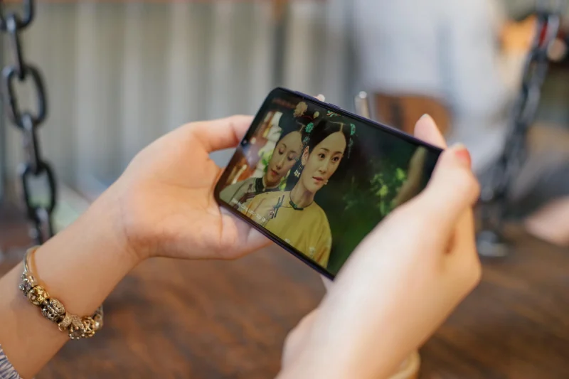 Người dùng cầm điện thoại xem phim truyền hình Việt Nam trên ứng dụng VTV Go